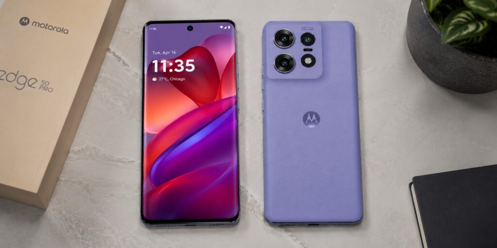 Motorola Edge 50 Pro smartphone in Luxe Lavender vegan leather finish showcasing its curved pOLED display and triple camera system on a desk.